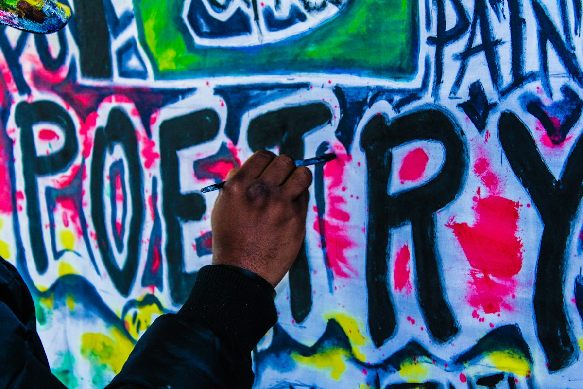 An artist painting a wall mural in Harare